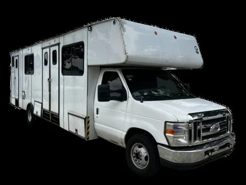 White Class C motorhome RV with cabover sleeping area on a Ford chassis, isolated on black background