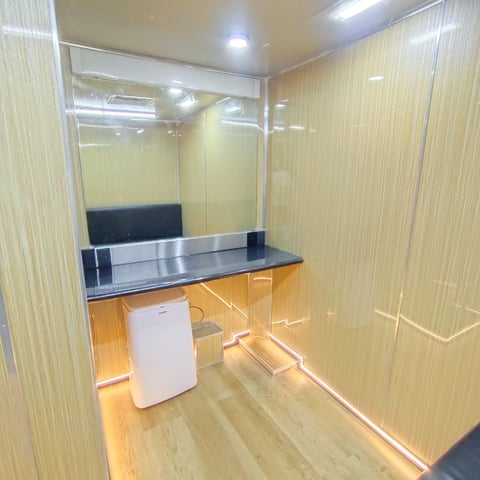 Modern bathroom interior with vanity sink, black countertop, large mirror, and yellow-beige tiled walls under bright lighting