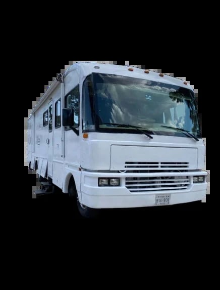 White recreational vehicle motorhome photographed from the front-side angle against a black background